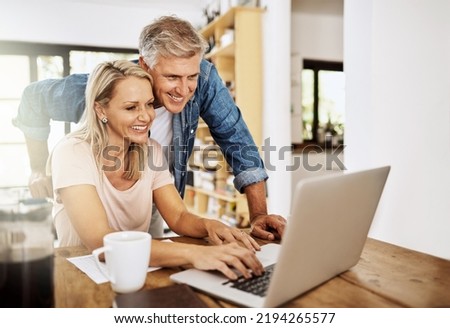Happy, smiling and mature couple using a laptop together at home. Charming husband assisting wife with online work on the internet. Cheerful Middle aged partners working as a team on social media. Royalty-Free Stock Photo #2194265577