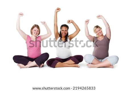 Pregnant, happy, and healthy, women sitting on the floor, arms raised in celebration of new life. Mothers, friends, and happiness during pregnancy, a group of future moms workout on white background