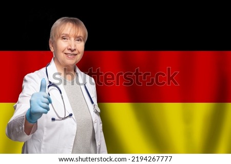 German smiling mature doctor woman holding stethoscope on flag of Germany background