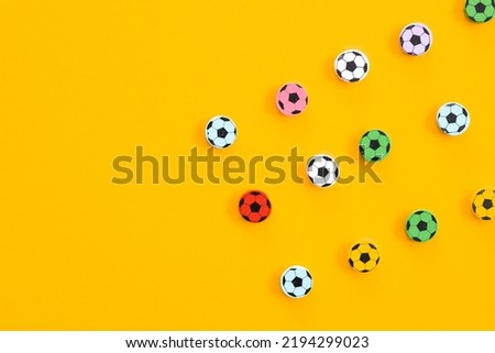 Wooden figures in the form of soccer balls on a yellow background