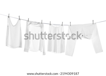 Different clothes drying on laundry line against white background Royalty-Free Stock Photo #2194309187