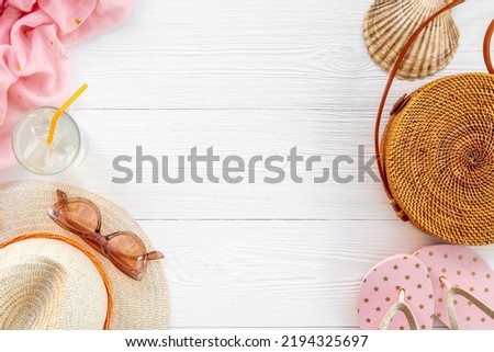 Flatlay of beach accessories with straw hat and rattan bag. Summer beach background