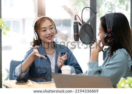 Smile two asian young woman, man radio hosts in headphones, microphone while talk, conversation, recording podcast in broadcasting at studio together. Technology of making record audio concept.

