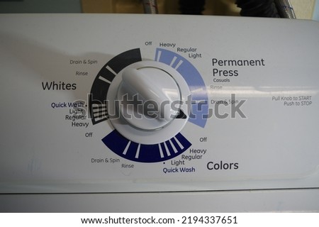 Washing machine control switch in off position, with wash options for colors, whites and permanent press. Royalty-Free Stock Photo #2194337651