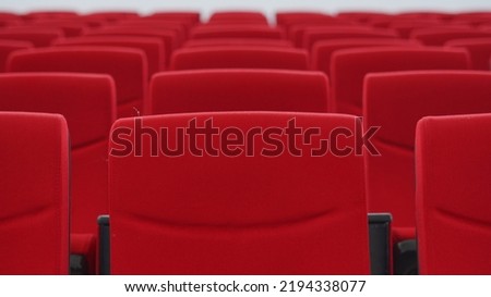 close up photo of rows of red seats in the cinema, theatre, concert, auditorium hall 