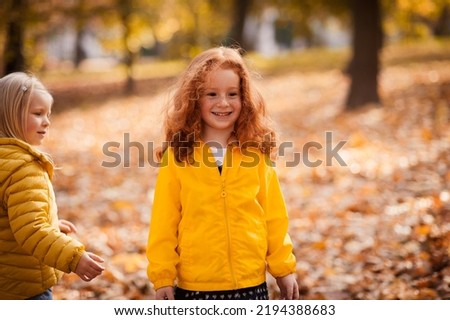 Red-haired girl in autumn leaves