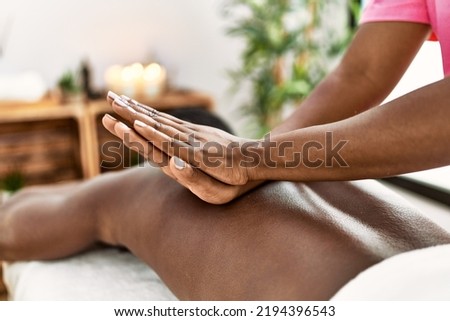 African american man reciving back massage at the clinic. Royalty-Free Stock Photo #2194396543