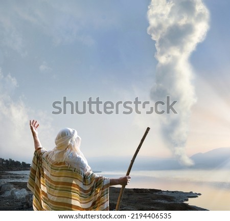 Retro holy Jesus Christ adult age wise saint male human rise arm hold wood wand rod cane back view. Middle east jew cloth Lord law torah exodus story magic egypt cloudy smoke sun light symbol concept Royalty-Free Stock Photo #2194406535
