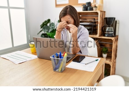 Middle age hispanic woman businesswoman working using laptop resting eyes at business office