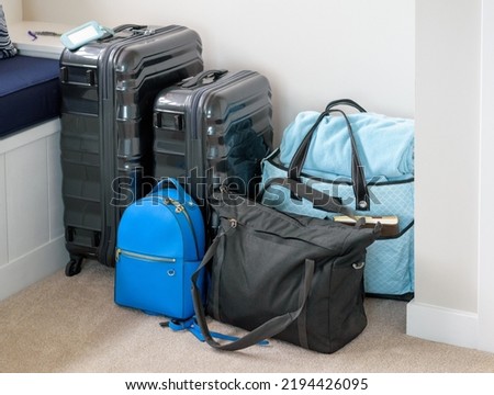 Suitcases, Backpack, Computer Bag, and Beach Bag Luggage Stacked and Ready to Travel Royalty-Free Stock Photo #2194426095