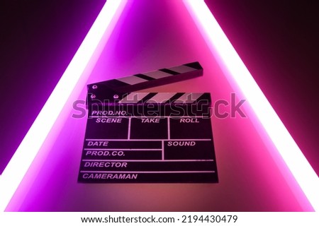 Clapperboard movie slate on Glowing neon lighting background. video director making cinema film. Film clapper design element. filmmaker clapperboard to make video film Royalty-Free Stock Photo #2194430479