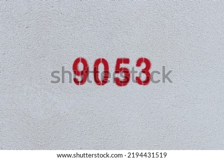 Red Number 9053 on the white wall. Spray paint.
