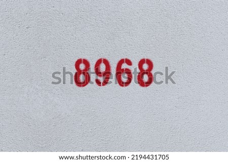 Red Number 8968 on the white wall. Spray paint.
