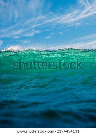 Crashing wave in ocean. Breaking turquoise wave with sun light