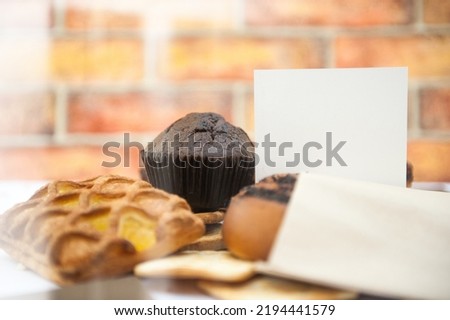 Bright pastries on a wooden backdrop template with empty white business card