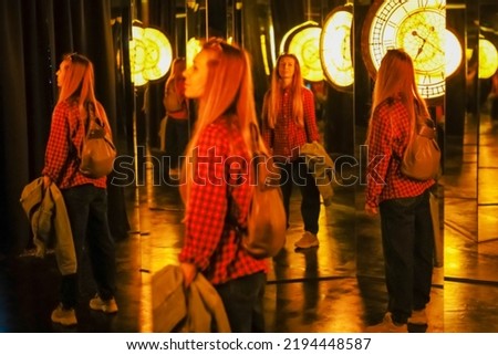 Woman in a mirror maze. Mirror labyrinth. Fairy tale museum with mirrors. Blurred image Royalty-Free Stock Photo #2194448587