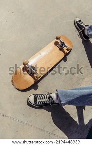 cropped view of man in gumshoes near skateboard lying upside down