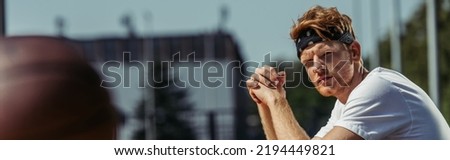 young sportive man in headband sitting outdoors, banner