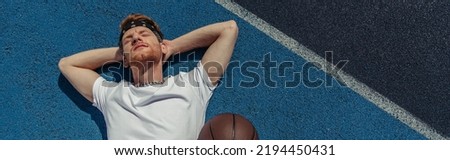 high angle view of basketball player resting on court near ball, banner