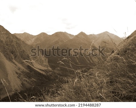 Vintage misty landscape with hills and rocks in sepia tones.