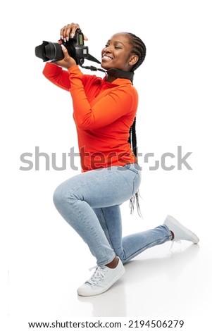 people, profession and photography concept - happy smiling woman photographer with digital camera photographing over white background