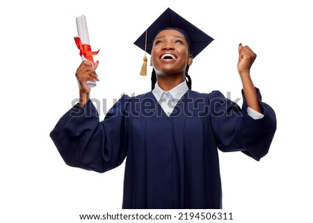 education, graduation and people concept - happy graduate student woman in mortarboard and bachelor gown with diploma celebrating and making winning gesture over white background Royalty-Free Stock Photo #2194506311