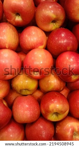 Piles of shiny red apples on supermarket display. 