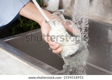 Woman washing glass bottles with a bottle brush Royalty-Free Stock Photo #2194518955