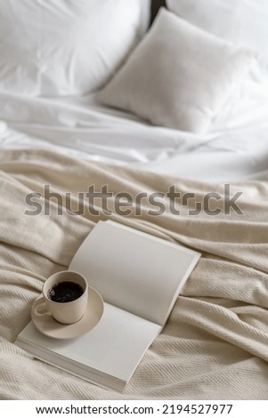 High angle view of morning coffee in ceramic cup with blank page diary journal on bed. Beverage cup and copy space open book in bedroom. Inspiration, imagination idea. Spending weekend at home concept Royalty-Free Stock Photo #2194527977