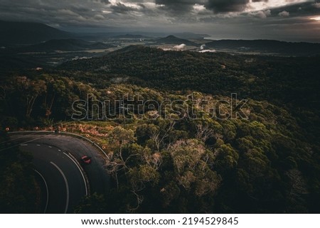 scenic view from the Julatten Lookout in far north queensland looking over Mossman and Port Douglas featuring a road, dense forest and stormy rural country landscape