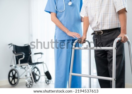 Physiotherapist assists her contented senior patient on folding walker. Recuperation for elderly, seniors care, nursing home. Royalty-Free Stock Photo #2194537613