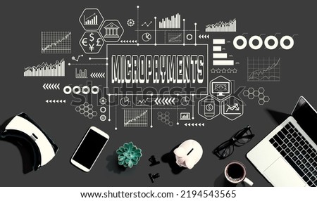 Micropayments theme with electronic gadgets and office supplies - flat lay Royalty-Free Stock Photo #2194543565