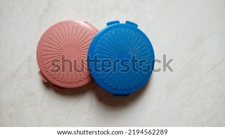 Two small red and blue medicine containers