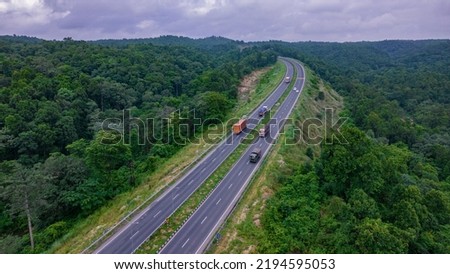 Aerial view of road going through greenery, Roads through the green forest, drone landscape Royalty-Free Stock Photo #2194595053