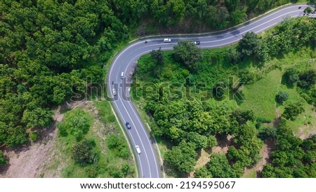 Aerial view of road going through greenery, Roads through the green forest, drone landscape Royalty-Free Stock Photo #2194595067