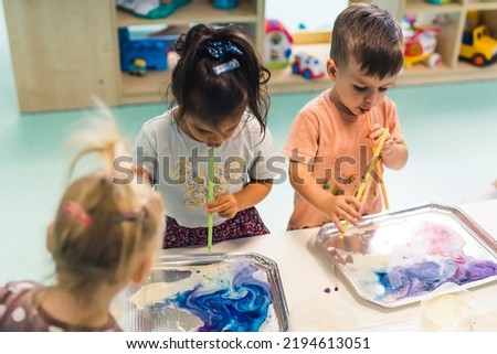 cute little children using creative art techniques for their painting, Ebru art. High quality photo