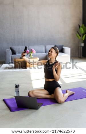 Full body profile side photo of young attractive woman break pause sit mat make selfie cellphone sportswear home