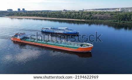 Cruises on the liner along the Volga. Passenger ship with tourists on board flying to overtake a tanker in Volgograd. Russia