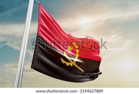 Angola national flag waving in beautiful clouds.