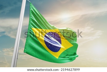 Brazil national flag waving in beautiful clouds.