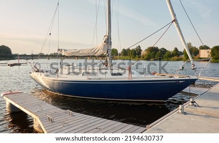 Sloop rigged sailboat (for rent and sale) moored to a pier in a yacht marina. Nautical vessel, transportation, amateur sailing, vacations, cruising, recreation concepts Royalty-Free Stock Photo #2194630737