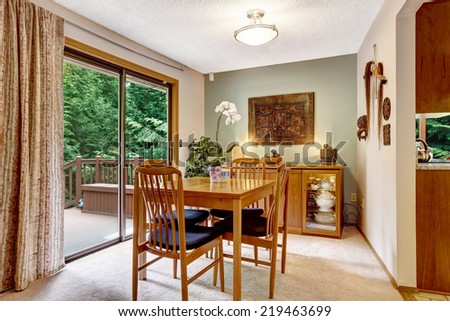 Cozy dining room with dining table set and cabinet. Room has exit to walkout deck