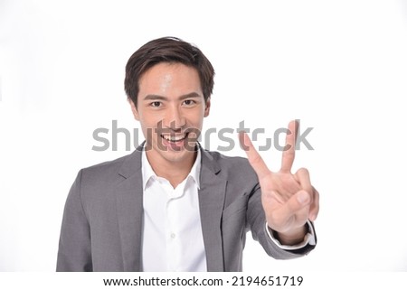 portrait of young businessman in gray suit,white shirt with showing two finger