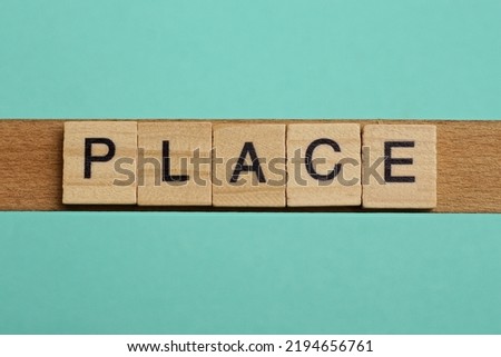 word place made of small gray wooden letters on a green paper background Royalty-Free Stock Photo #2194656761