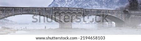 Universal banner panoramic photo of a stone railway bridge across the river