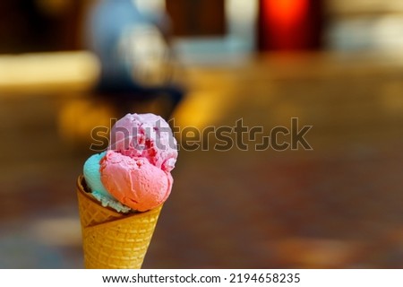 Ice cream from pink, purple and blue balls in a waffle cone