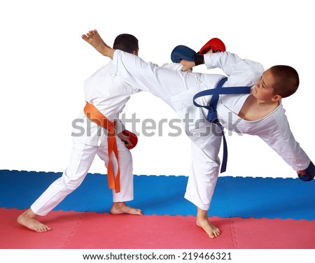 Blow ura-mawashi geri against the punch arm in perfoming sportsman in karategi Royalty-Free Stock Photo #219466321