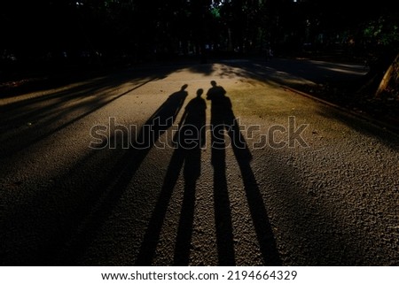 Shadows of three people from the sun.