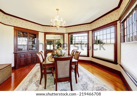 Luxury dining room with wood trim and built-in cabinet. Decorated family dining table .