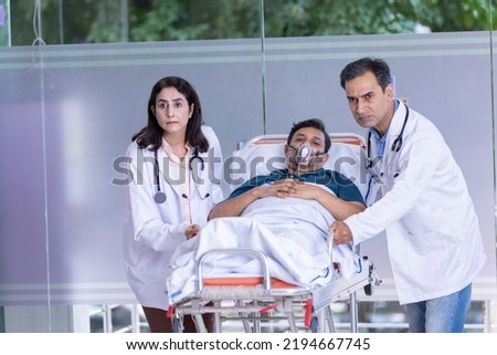 Doctors pushing old patient on emergency stretcher bed Royalty-Free Stock Photo #2194667745